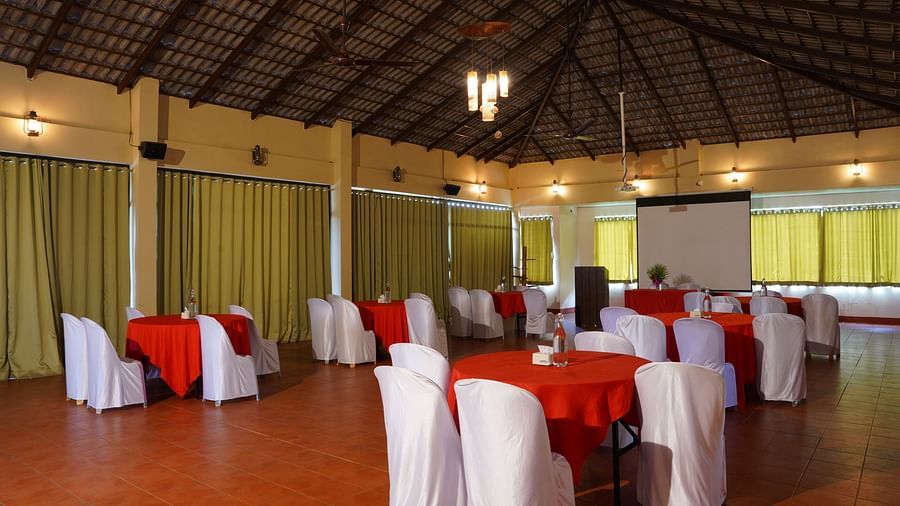 A decorated table at Forest Escapes Koyna features floral arrangements, set for a special occasion or event.