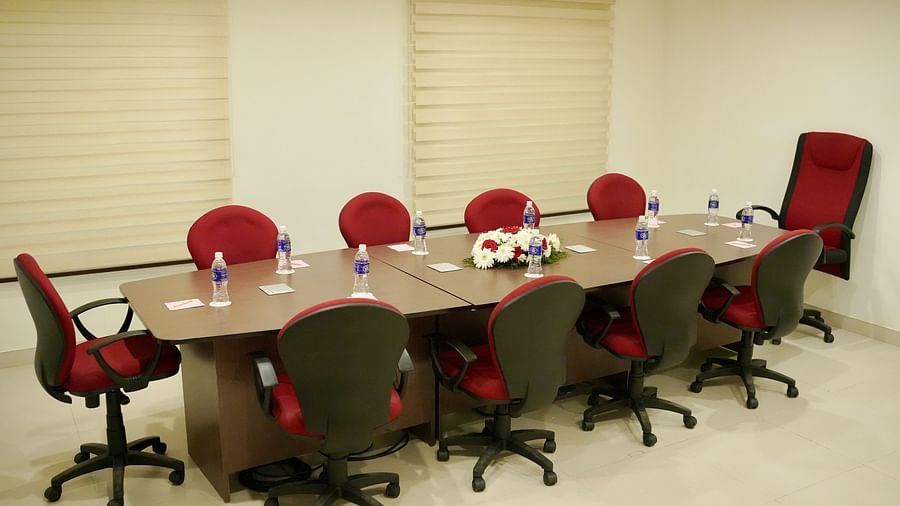 Chairs and table arranged in a boardroom setup, ready for the meeting
