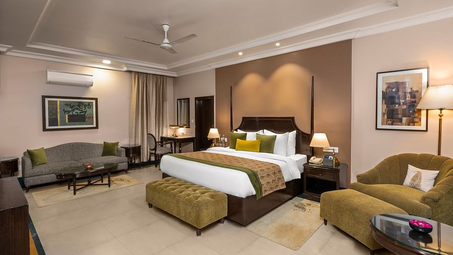 Ganga View Suite with two sofas and a large bed in the middle with green covers - Ganga Lahari, Haridwar