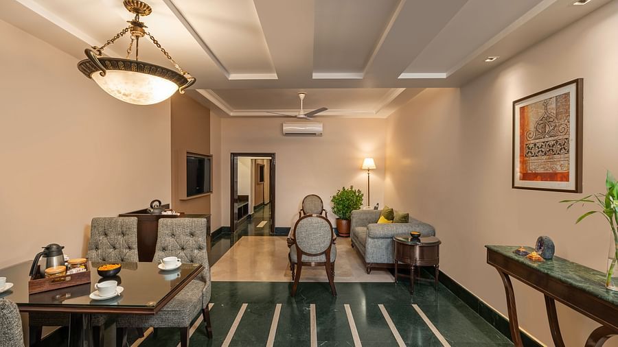 Maharaja Suite Living Room with a table set for dining and sofas for sitting - Ganga Lahari, Haridwar