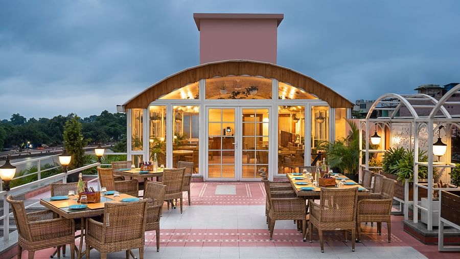 Restaurant Patio with the outdoor dining arrangement with tables and chairs  in clusters - Ganga Lahari, Haridwar