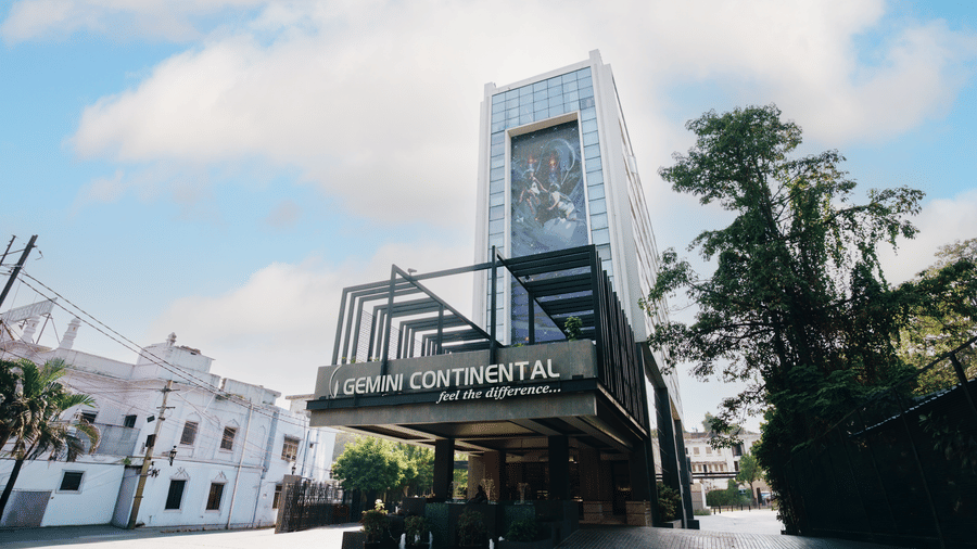 Exterior view of the Gemini Continental hotel, featuring a modern high-rise building with a large mural and a prominent entrance sign.