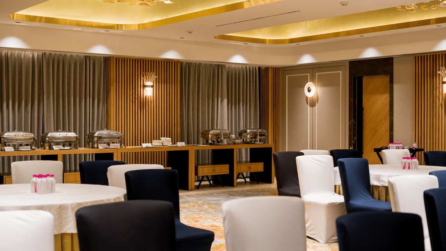 Galaxy 1 event hall at Gemini Continental with multiple round tables, chairs around them, accent walls and modern lighting.