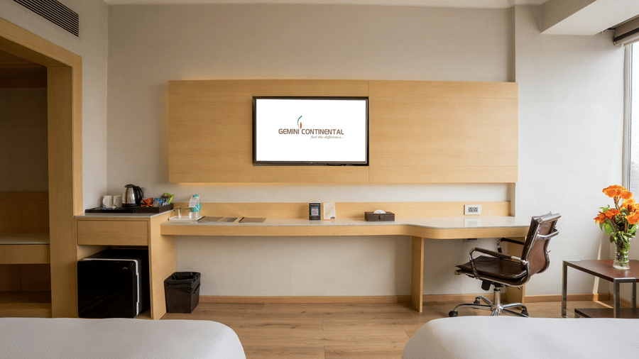 A Standard Room with 2 beds, a flat-screen television, a desk and a chair, and a minibar at Gemini Continental.