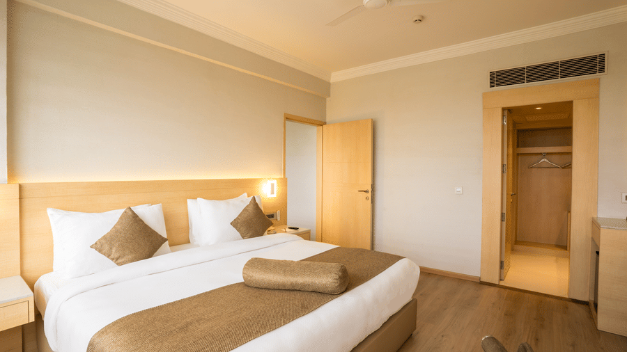 Suite at Gemini Continental featuring a bed with plush decorative pillows and a bolster, a ceiling fan, and a walk-in closet.