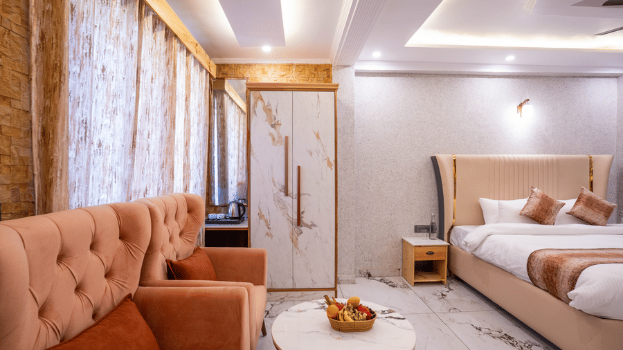 A well-lit lounge area inside the suite featuring comfortable tufted sofas and a coffee table - Golden Oak By The Lake Hill, Khurpatal