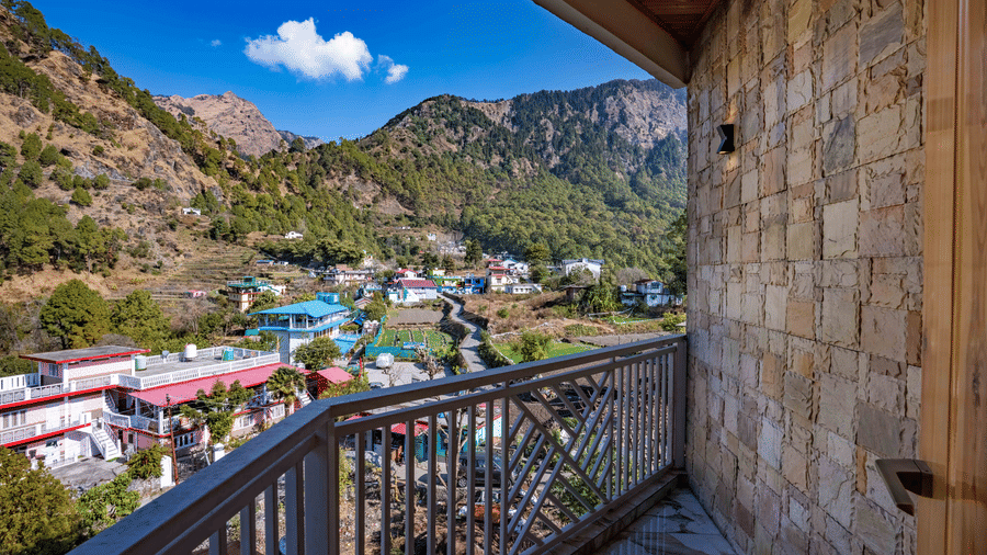 A scenic view from a stone-walled balcony overlooking lush green mountains and a village - Golden Oak By The Lake Hill, Khurpatal