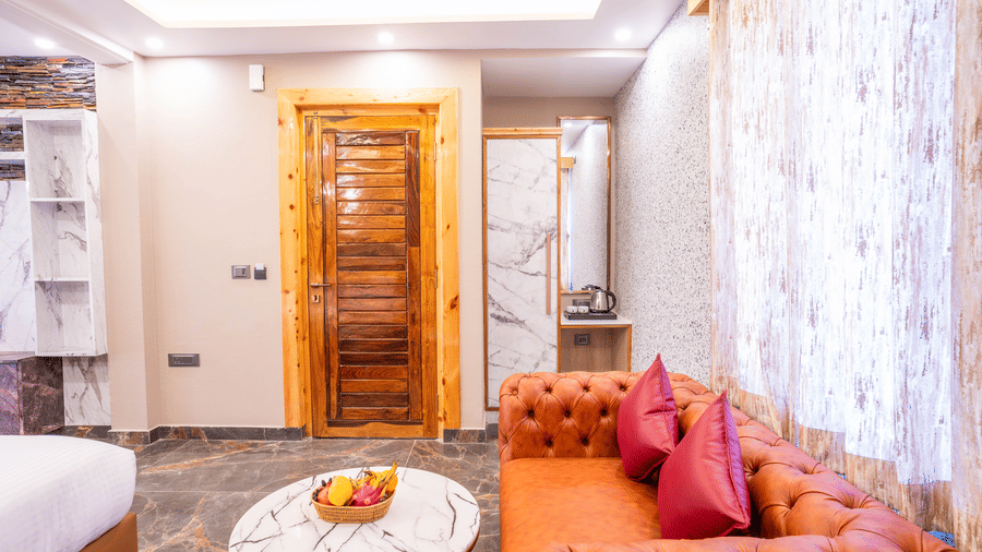 A cozy seating corner with a vibrant orange tufted sofa and a marble coffee table - Golden Oak By The Lake Hill, Khurpatal