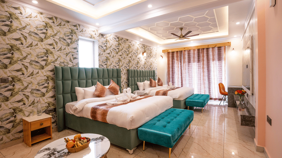 An expansive family suite with multiple beds, teal accents, and warm recessed ceiling lighting - Golden Oak By The Lake Hill, Khurpatal