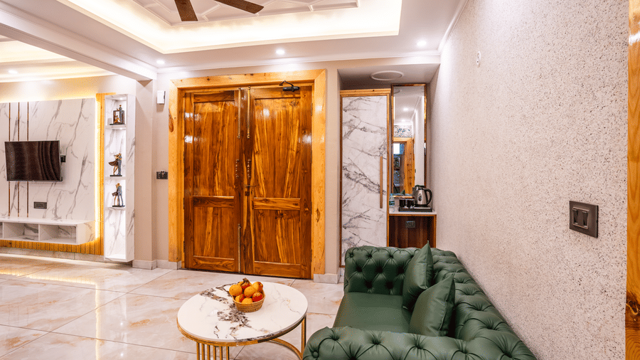 A cozy seating area featuring a green tufted sofa and a marble-top coffee table - Golden Oak By The Lake Hill, Khurpatal