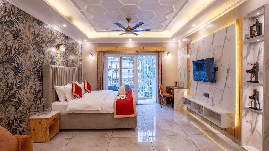 A bright hotel suite showing the bed and a large glass door leading to a balcony - Golden Oak By The Lake Hill, Khurpatal