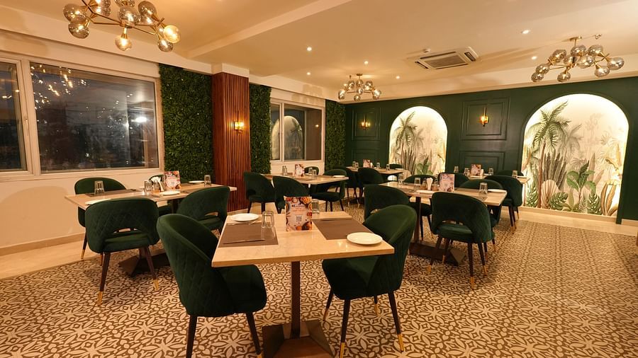 Contemporary dining area with elegant chairs and wall art - Grand Plaza Lords Inn Jammu