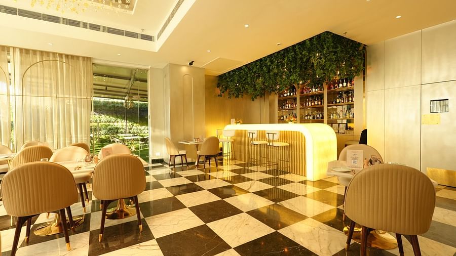 Elegant café-style dining area with beige chairs and sleek flooring - Grand Plaza Lords Inn Jammu