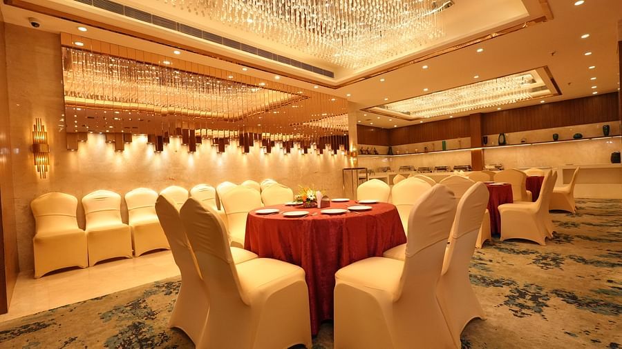 Spacious banquet room with chandelier and seating arrangement - Grand Plaza Lords Inn Jammu