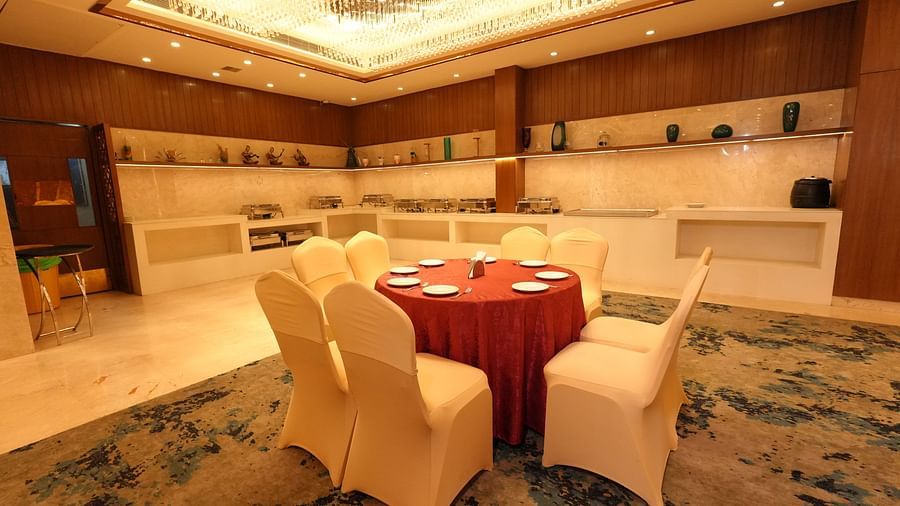 Dining area setup with a round table and cushioned chairs - Grand Plaza Lords Inn Jammu