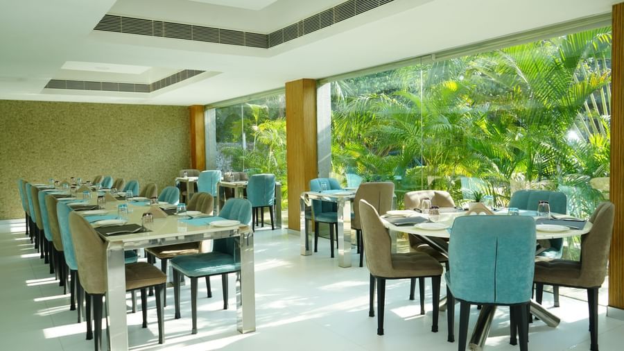 Dining tables and chairs arranged neatly in a bright restaurant space at Grande Bay Resort & Spa.