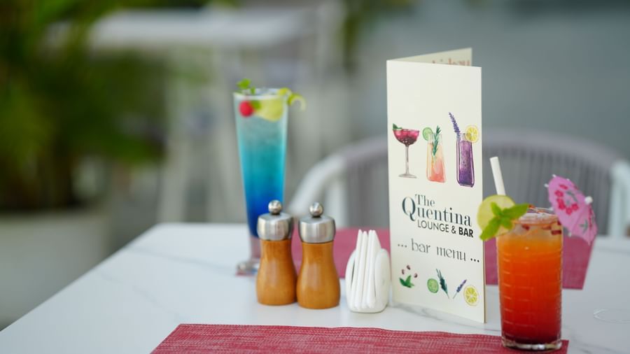 Outdoor table set with drinks, cutlery and a menu card at Grande Bay Resort & Spa.