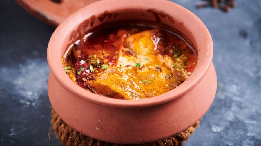 A clay pot of curry with oil and spices visible on the surface at Grande Bay Resort & Spa.