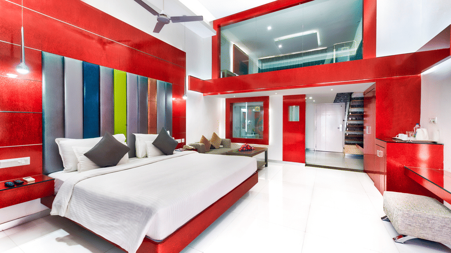A room with bold red-themed interiors, modern decor, spacious bedding area, and a staircase to the first floor - Grande Bay Resort & Spa, Mamallapuram