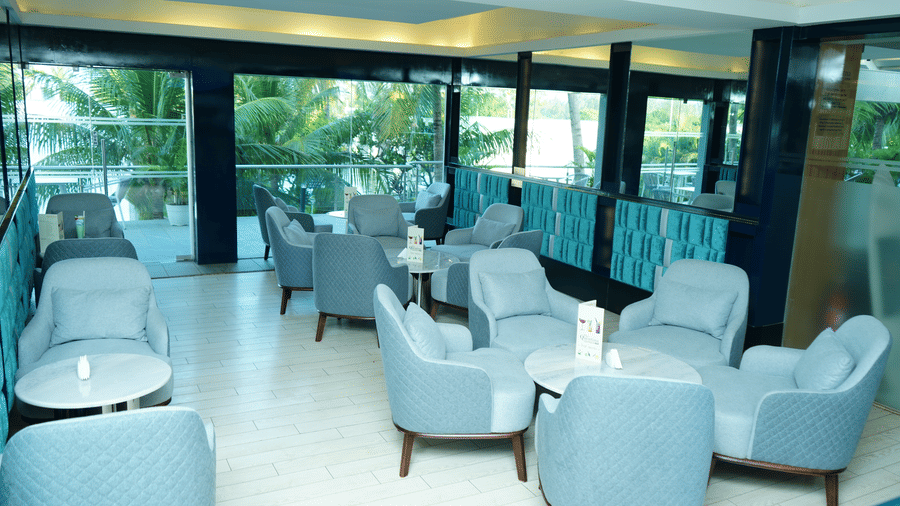 Spacious seating layout inside The Quentina Bar with multiple modern chair arrangements and bright natural light - Grande Bay Resort & Spa, Mamallapuram