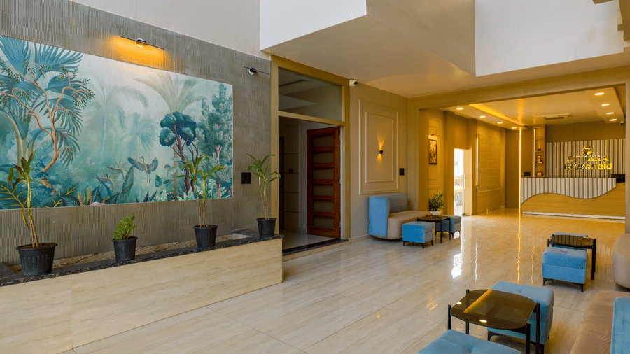 An interior shot featuring a large nature-themed mural on a stone-textured wall next to the lobby seating area at Grassfield Riveria Resort.