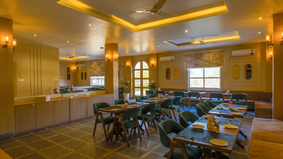 A wide view of the restaurant highlighting the tiled floor and rows of dining tables at Grassfield Riveria Resort.