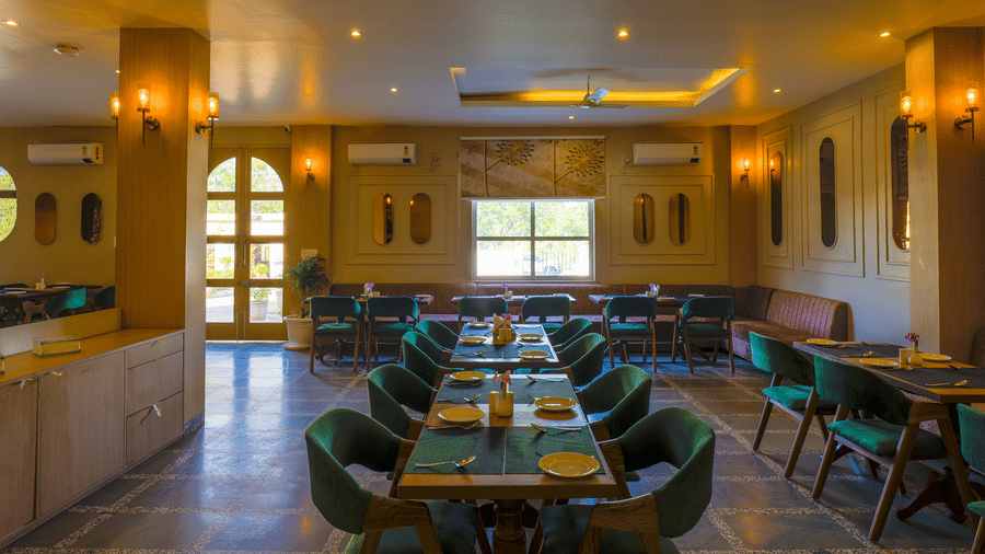 A view from the end of the dining hall showing the symmetrical arrangement of tables and chairs at Grassfield Riveria Resort.