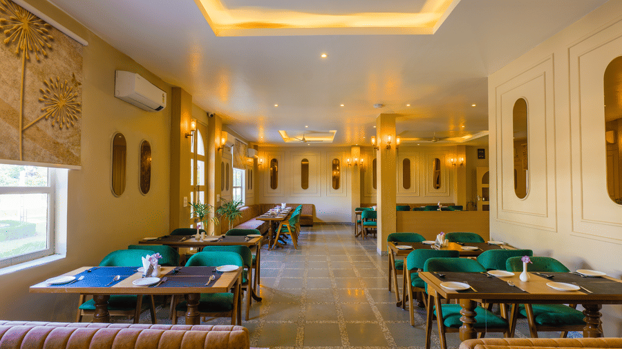 A brightly lit restaurant space with chairs and warm  lighting from the ceiling.