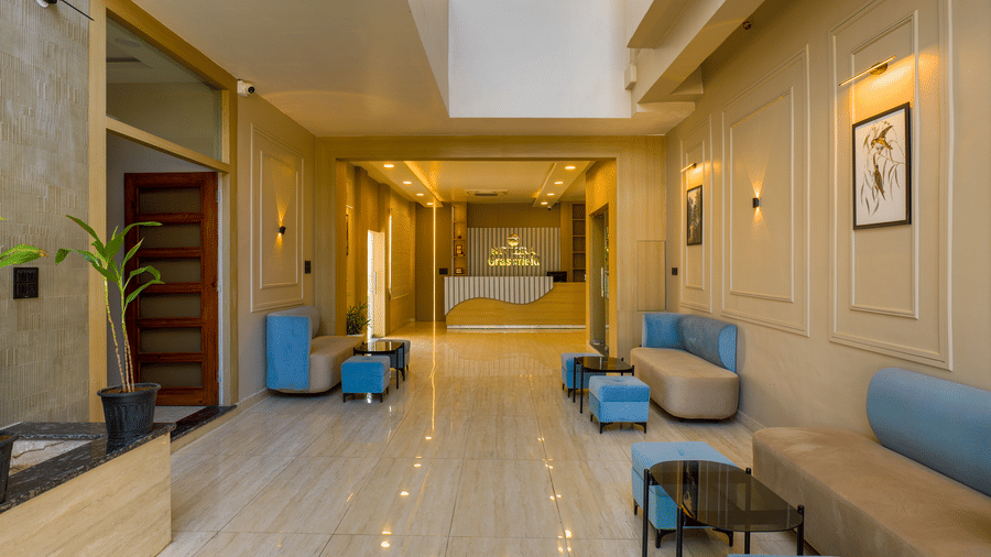 A long perspective of the lobby hallway showing a reception desk in the distance and sofas lining the wall at Grassfield Riveria Resort.