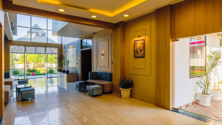 A view from the corner of the lobby looking toward the glass entrance with seating area at Grassfield Riveria Resort.