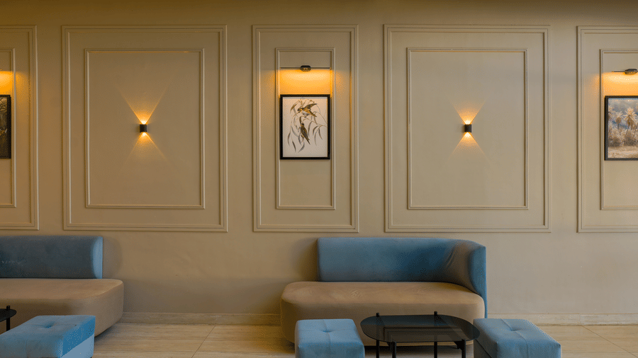 A close-up of the wall panelling and furniture showcasing wall-mounted light fixtures and decorative frames at Grassfield Riveria Resort.