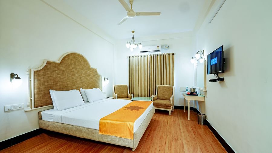 The hotel room from a different angle, emphasizing the space and the wooden floor at Greens Inn - Spacious Accommodation in Ramoji Film City.