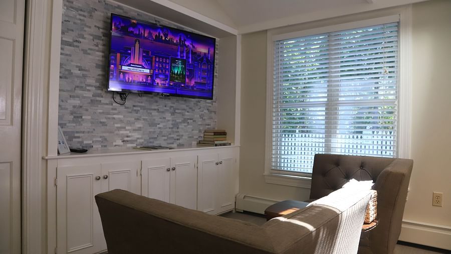 Seating area with chairs and mounted TV at Hartstone Inn.