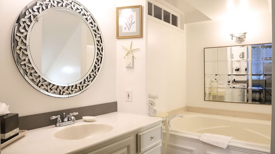 Bathroom with a mirror, sink, and a bathtub at Hartstone Inn.