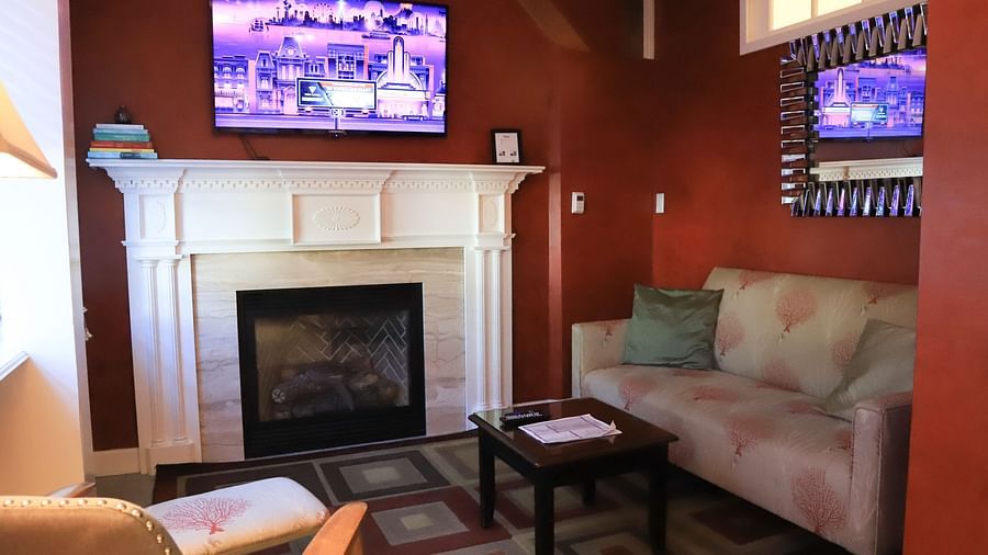Hotel room with a fireplace, TV, and sofa at Hartstone Inn.