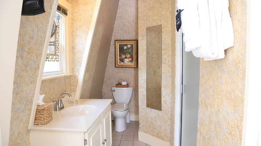 Elegant bathroom with vanity and slanted ceiling at Hartstone Inn