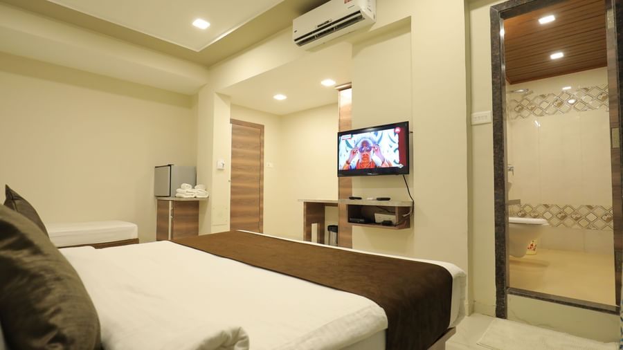 The king size bed and single bed in Highland Resort's suite facing the wall-mounted TV.