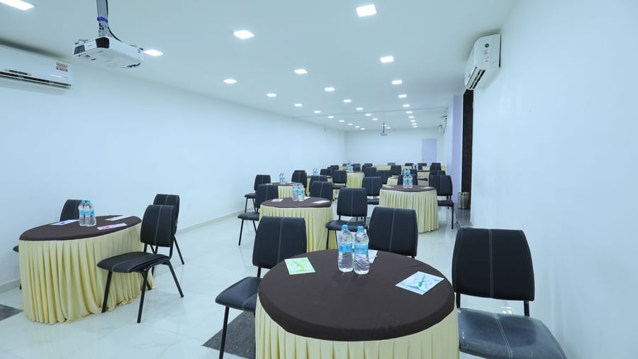 Round tables covered with table cloth, with chairs, water bottles, additional stationary, in the Regency banquet hall of Highland Resort.