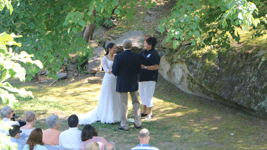 a couple getting married with the guests sitting in front of them witnessing the matrimony - Historic Tapoco Lodge