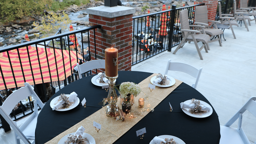corner view image of the dining table on the terrace besides the hand railing - Historic Tapoco Lodge
