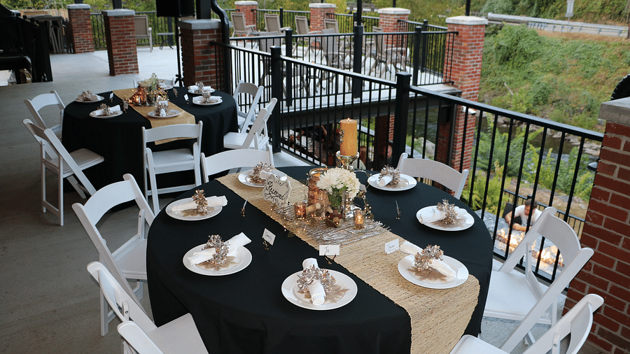 a dining table with black and beige colored table clothe with properly arranged cutlery - Historic Tapoco Lodge