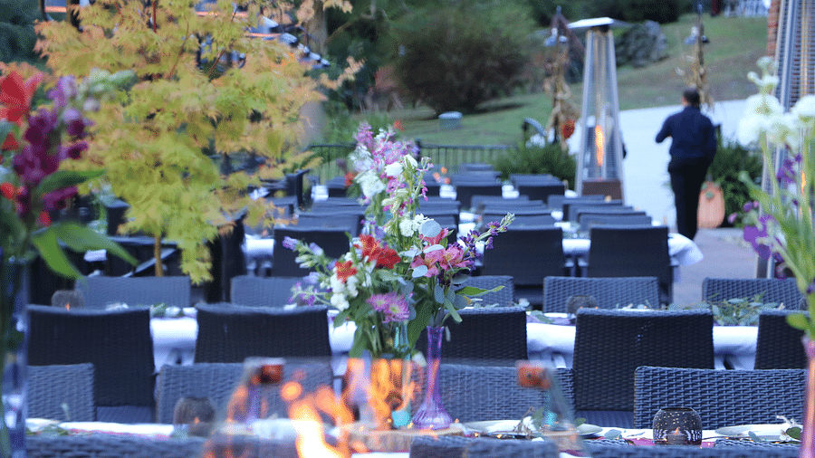 an outdoor seating with a fire pit and floral arrangements near the riverside - Historic Tapoco Lodge