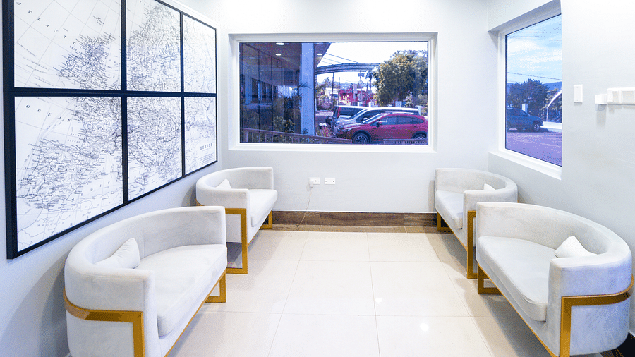 An image of a travel agency with white sofas and a wall-mounted representing the world map - Hotel 39, Jamaica (Montego Bay)