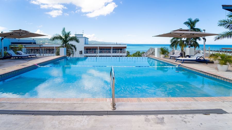 A close up shot of a pool with clear water and views of Montego Bay in the background - Hotel 39, Jamaica (Montego Bay)