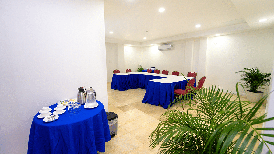 A cosy conference room setup with deep blue tablecloths and lush plants - Hotel 39, Jamaica (Montego Bay)