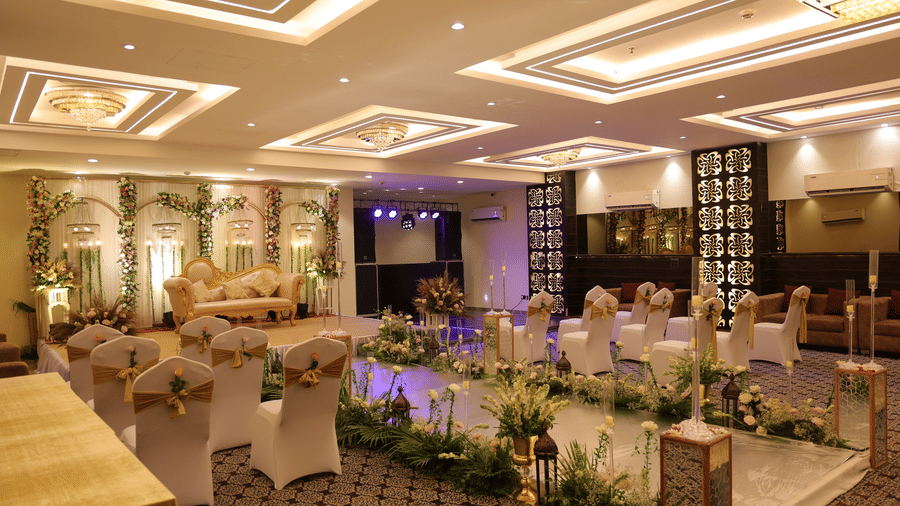 A wide view of a luxury event space featuring recessed ceiling lighting, floral aisle decor, and carpeted flooring - Hotel 91 HUDA City Centre, Gurugram