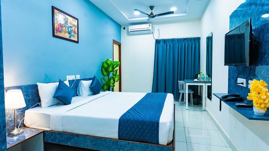 An image of a bedroom with king size bed, bedside table next to it, AC, flat TV screen, etc. - Hotel Aerotel, Hyderabad - A Unit of Comfort Hometel