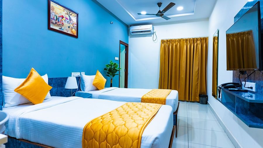 An image of a bedroom with twin bed, bedside table next to it, AC, flat TV screen, etc. - Hotel Aerotel, Hyderabad - A Unit of Comfort Hometel