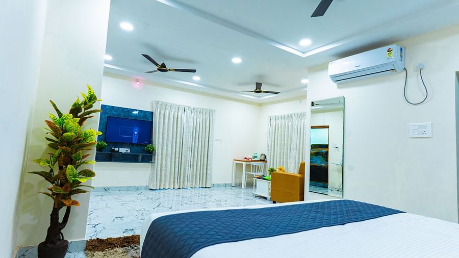An image of a bedroom with TV, flat TV screen, fans, and other room amenities - Hotel Aerotel, Hyderabad - A Unit of Comfort Hometel