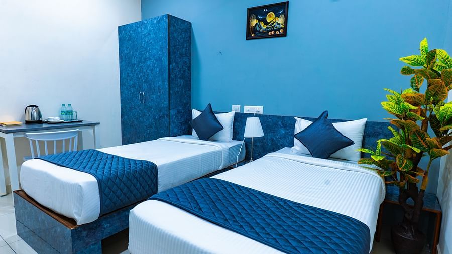 An image of a bedroom with twin bed, bedside table next to it, AC, flat TV screen, etc. - Hotel Aerotel, Hyderabad - A Unit of Comfort Hometel